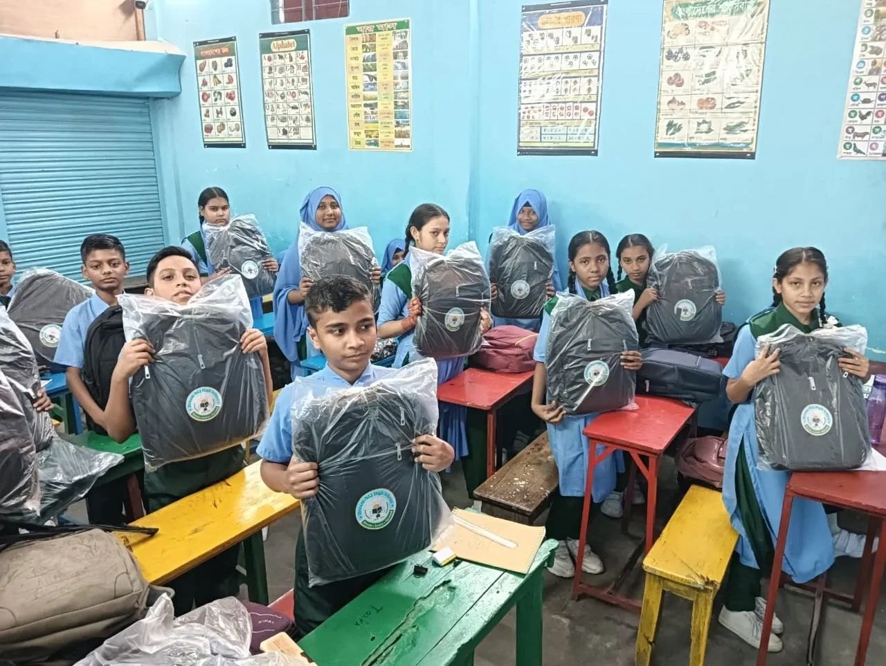 Students in a HAKF-supported classroom holding new school backpacks