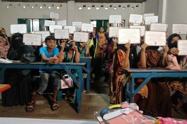 Graduates holding their training certificates